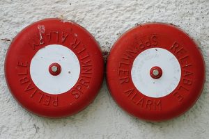 A picture of two fire bells on a wall helping keep employees safe