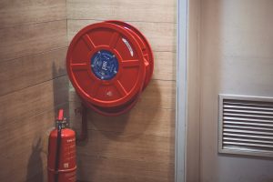 A fire extinguisher and hose reel on a wall - legal requirements of the fire safety order